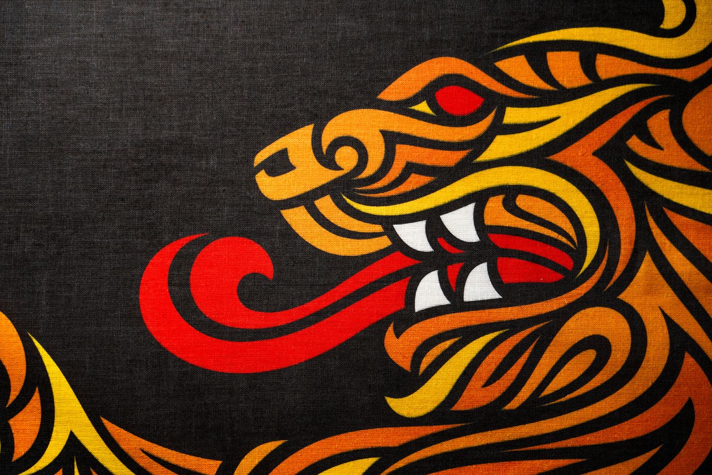 A dragon printed in orange, yellow and red on black hemp cloth