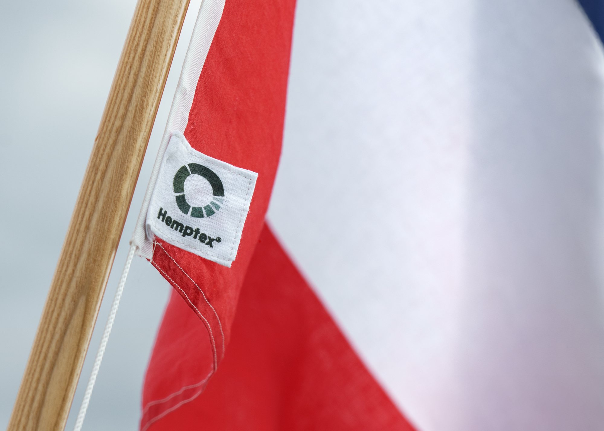 The Hemptex label sewn onto a red and white flag on a wooden pole